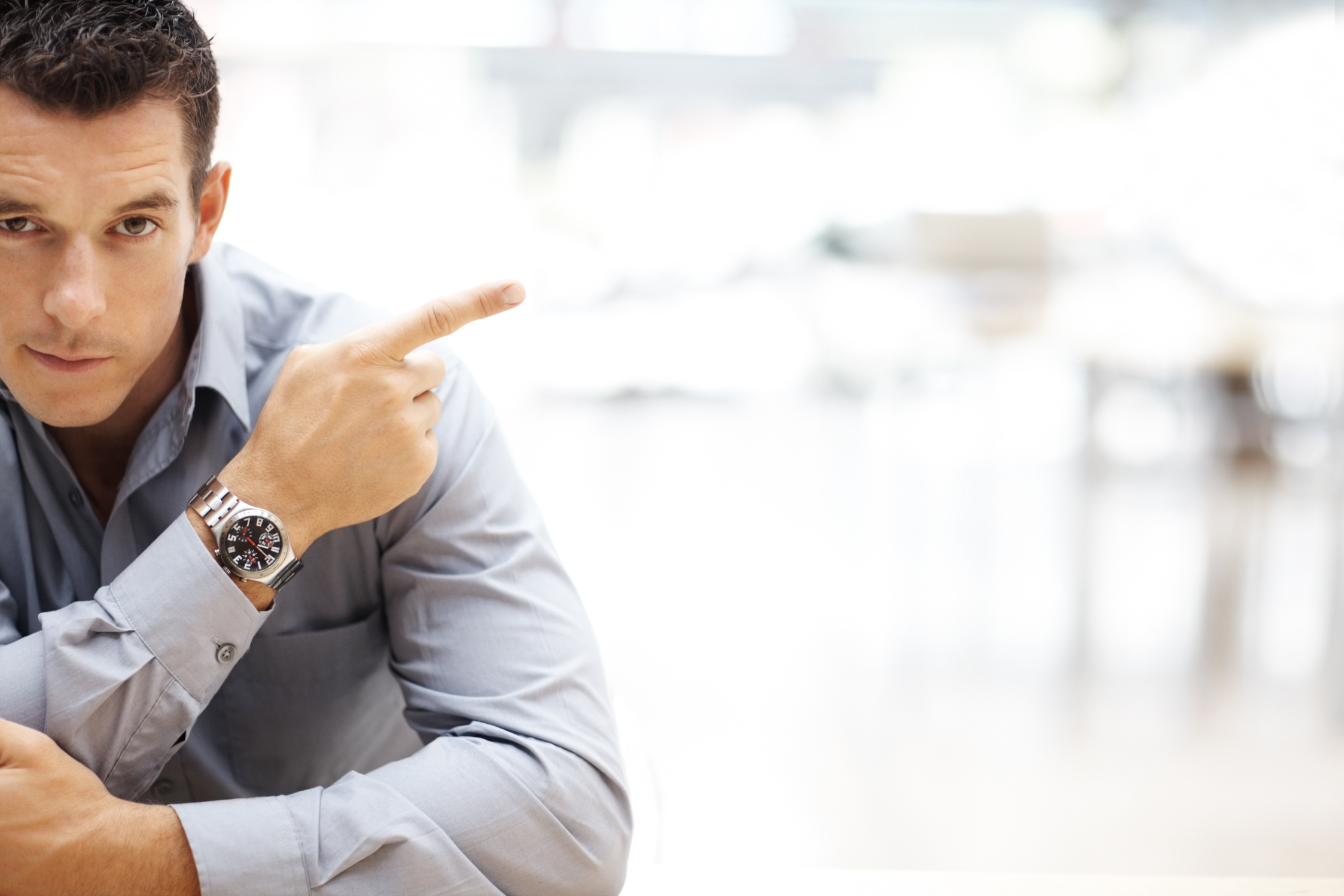 Young male entrepreneur pointing at copyspace