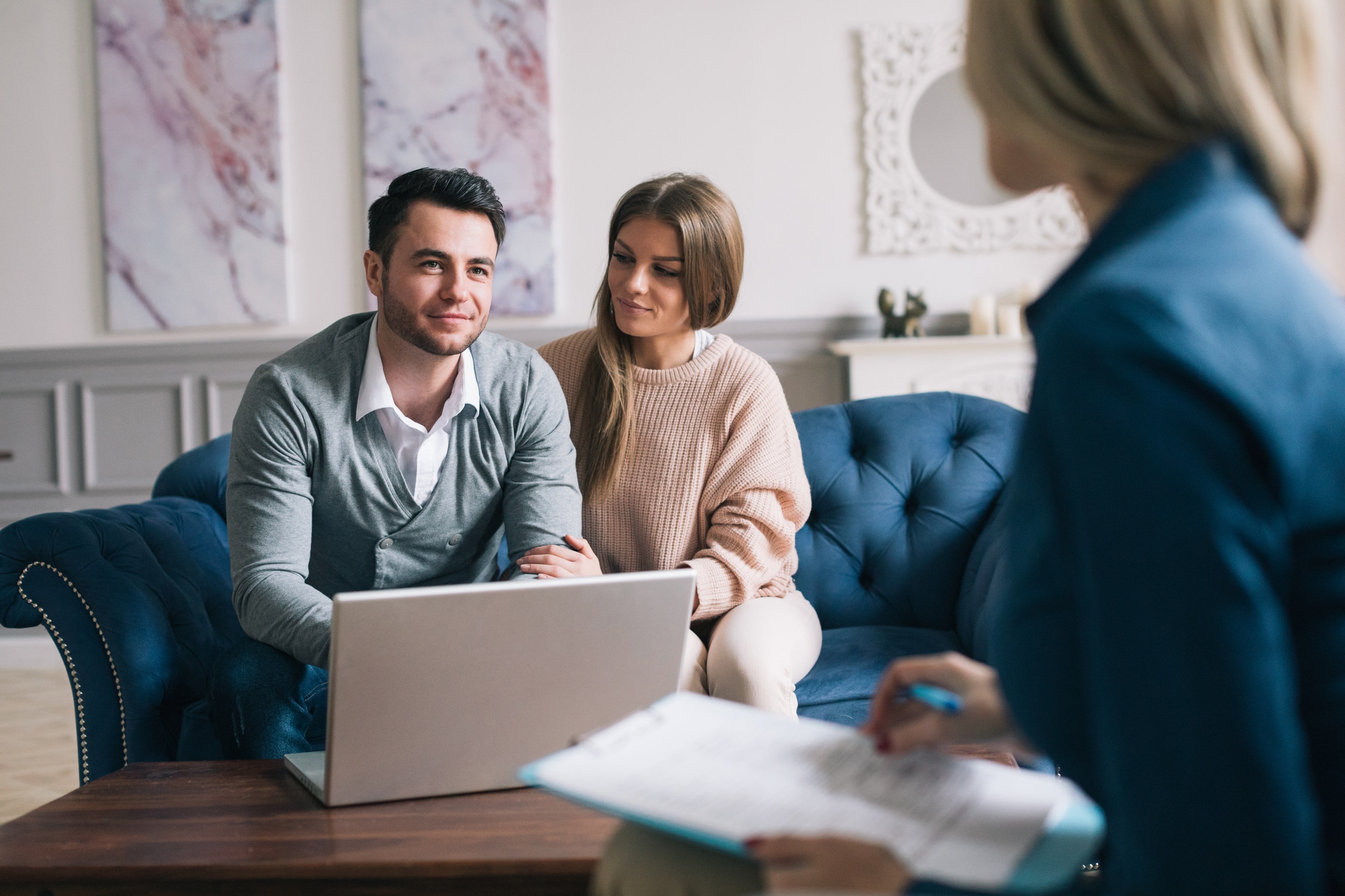 Happy couple planning their future while consulting with insurance agent in their home.