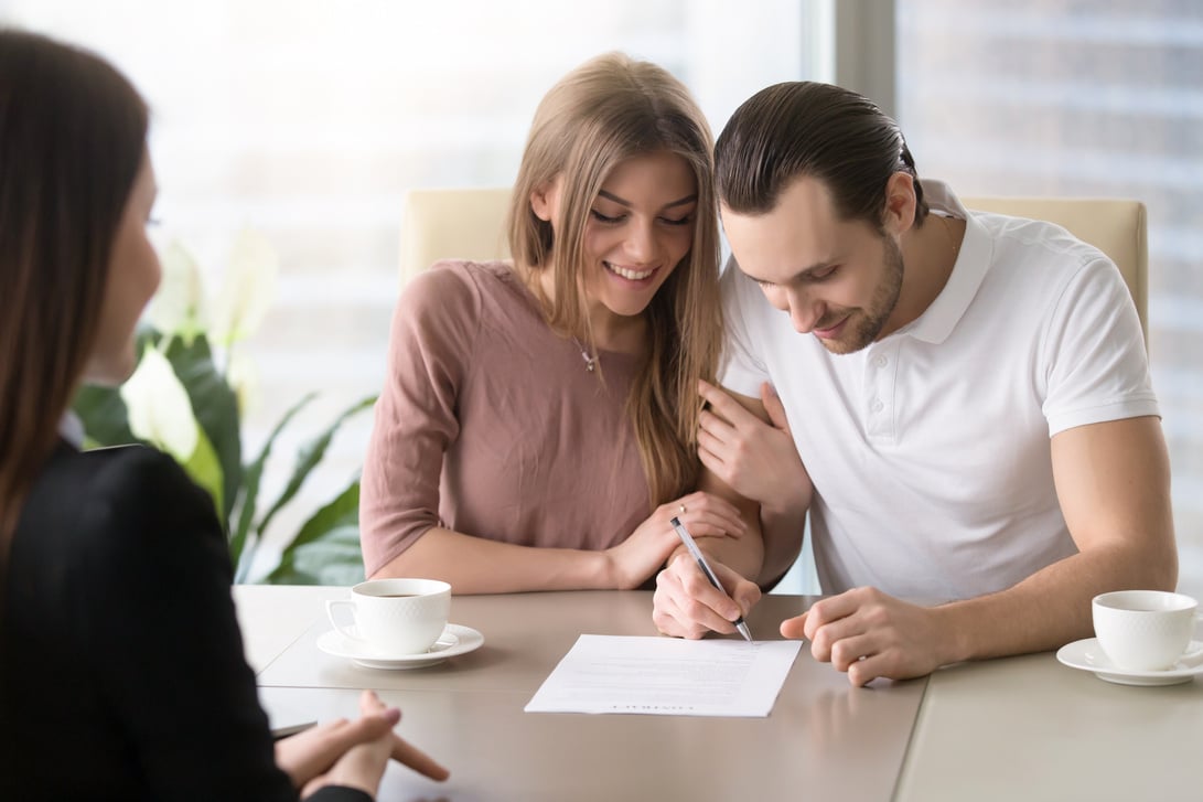 Happy family couple signing document, taking out bank loan, insurance